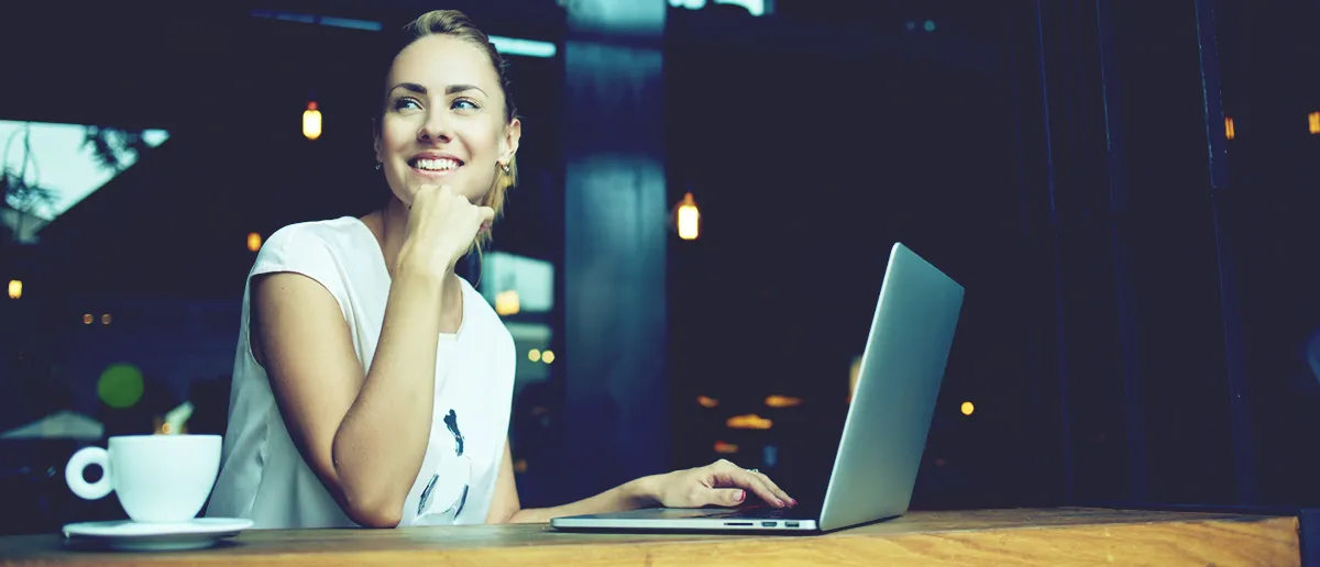 Woman smiling while working on a laptop