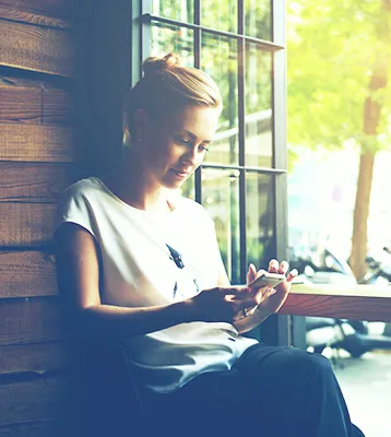 Woman reading her mail at a sunny window
